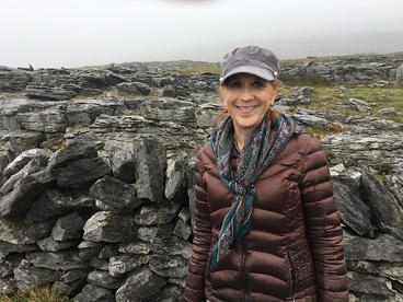 Debbie Ringdahl standing in front of rocks in a brown parka